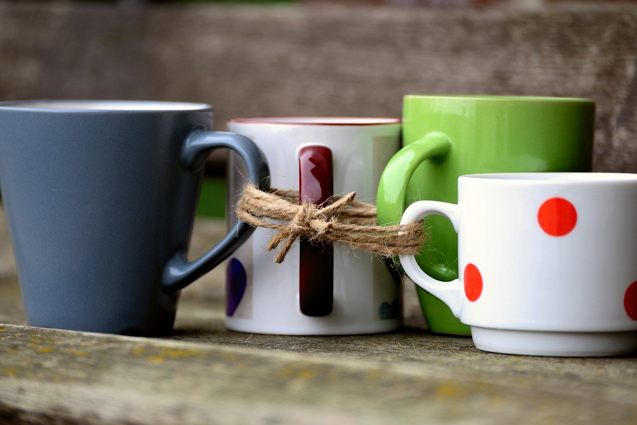 4 coffee mugs on a table tied together with a cord